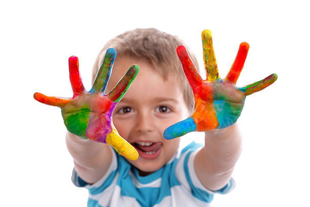 Boy with hands painted in colorful paints ready to make hand prints